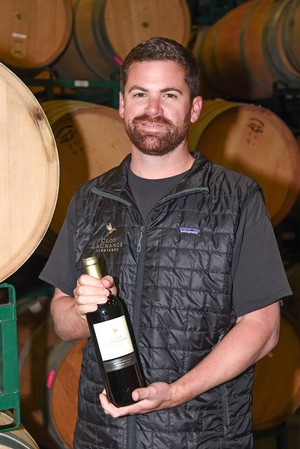 Steve Driscoll with a bottle of wine in hand in the barrel room